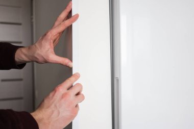 Adam apartmanın duvarına koruyucu plastik yapıştırıcı yapıştırıyor..