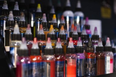 Renkli dövme mürekkebi paleti. Dövme salonu. Seçici odak, bulanık.