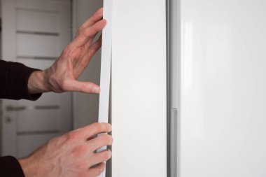 Mans eller apartmanın duvarına koruyucu dekoratif köşe kuruyor..