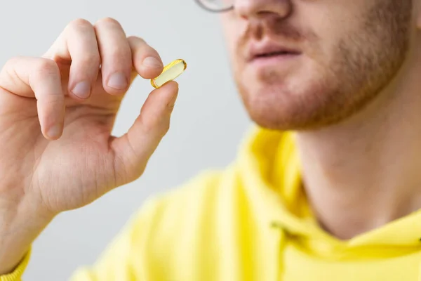 Gülümseyen adam vitamin alıyor. - Yakın çekim. Sağlık ve İlaç Hizmetleri.