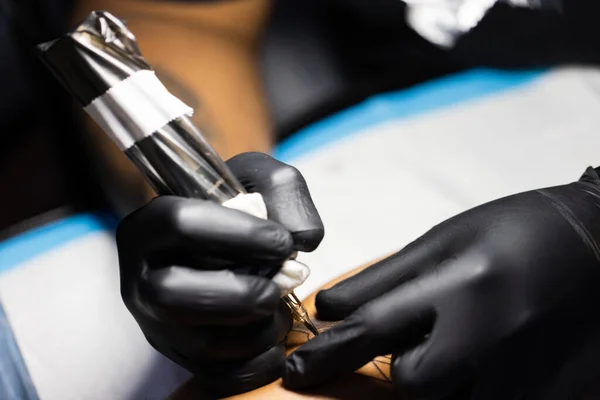 Máquina de tatuagem na mão do tatuador. — Fotografia de Stock