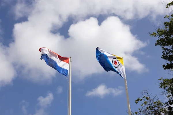 Bandeira de Bonaire e Holanda voando ao vento no fundo do céu azul. — Fotografia de Stock