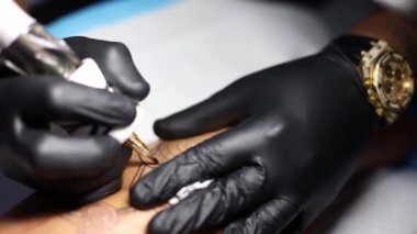 Dövme ustasının elleri dövme salonundaki işlerle meşgul. Kapat..