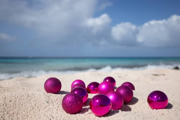 Roze kerstballen op het strand. Kerstmis in de tropen. Selectieve focus — Stockfoto