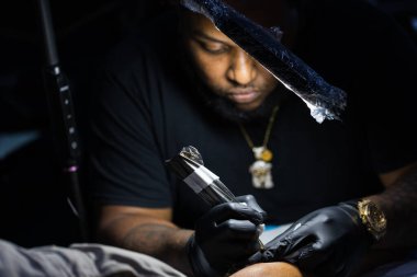 Dövme sanatçısının portresi işine odaklandı. Yakın çekim.