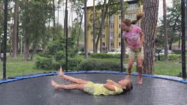 4k dívky dvojčata skákání na trampolíně v létě. — Stock video