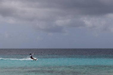 Fırtınalı havada uçurtma sörfü yapan tanınmayan biri..
