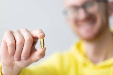 Elinde vitamin tutan gülümseyen adam. - Yakın çekim. Sağlık ve İlaç Hizmetleri.