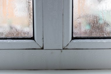 Yoğunlaşmış pencere camı, camlara doğal su damlaları, yüksek nem. Seçici odak.