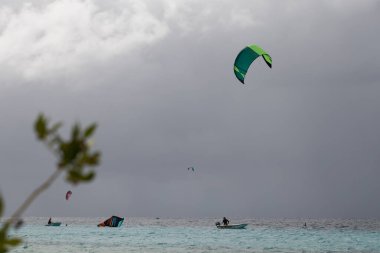 Fırtınalı havada uçurtma sörfü yapan tanınmamış insanlar..
