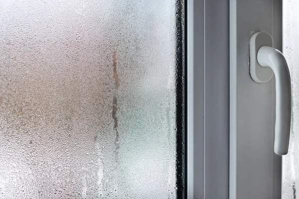 Yoğunlaşmış pencere camı, camlara doğal su damlaları, yüksek nem. Bulanık.