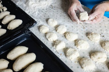 Kadınların elleri turta için hamuru yuvarlıyor. Evde pişirme