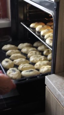 Kadın elleri fırına turta koyuyor. Dikey.