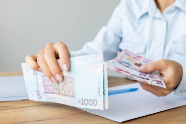 Ukraynalı 1000 'lik banknot ve 200' lük banknot tutan kadın. Ukrayna parası.