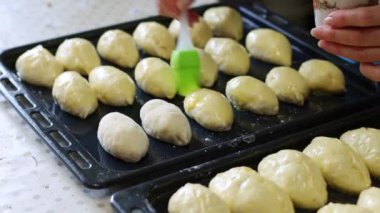 Kadın fırına koymadan önce çırpılmış yumurtalarla turta fırçalıyor. Ev yapımı..