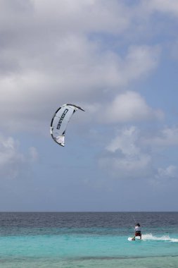 Fırtınalı havada uçurtma sörfü yapan tanınmayan biri..