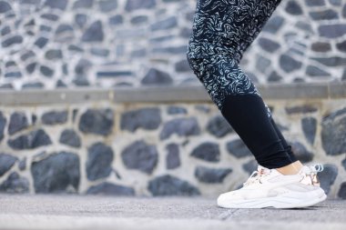  Spor elbiseli kadın atlamaya hazır. Deri taytlı kadın bacakları.