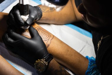 Dövme sanatçısı işine odaklanmış. Yakın çekim.