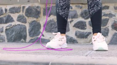  Kadınların ayakları sporda, parkın yakın çekimlerinde ip atlıyor. 4K görüntü