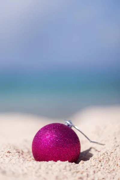 Pink Christmas Glitter Bal Het Zand Blauwe Lucht Zee Achtergrond — Stockfoto