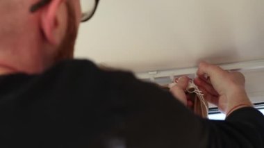 Plastik kancalara perde asan bir adam. 4k görüntü