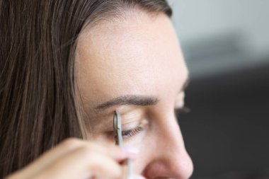 Kaşlarını yolan Kafkas bir kadın. Yakın çekim, seçici odaklanma