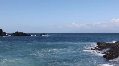 Sörf dalgaları beyaz su molası ile bir resifin üzerinde yuvarlanıyor. 4k görüntü