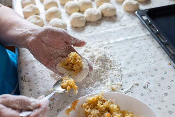 Woman cooking pies with cabbage filling at home. Cooking and baking at home