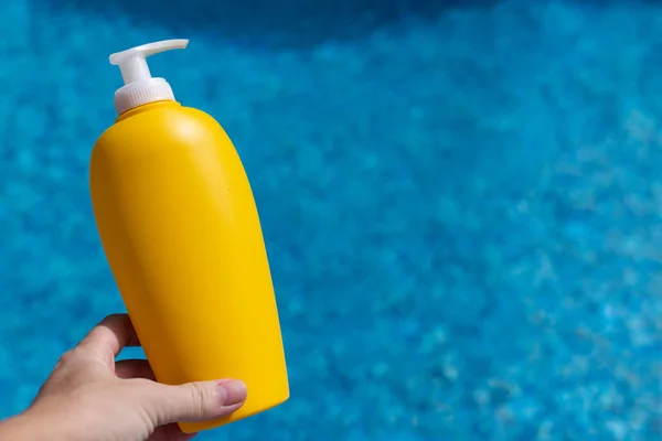 Sunscreen Bottle Hand Blue Water Swimming Pool Background Mockup — Fotografia de Stock