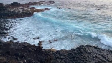 Okyanus dalgaları olan kayalık sahil doğası. Tenerife 'nin akşam doğası. 4K görüntü.