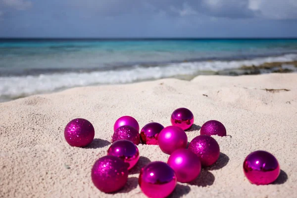在沙滩上的粉色圣诞球 热带地区的圣诞节有选择的重点 — 图库照片