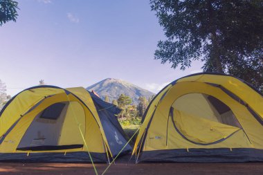 İki sarı çadır, Endonezya 'nın Java adasının doğal manzarasının tadını çıkarırken kamp yapmak için uygundur.