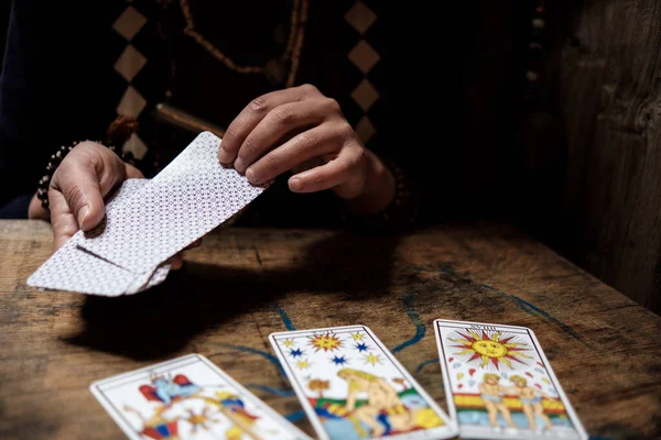 Ahşap masadaki psişik kartları kapat. Gelecek konsepti. Kadın elleri.