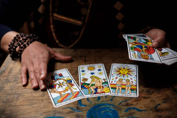 Tarot kartlarını ve onları kullanan kadın ellerini kapat. Gelecek konsepti.