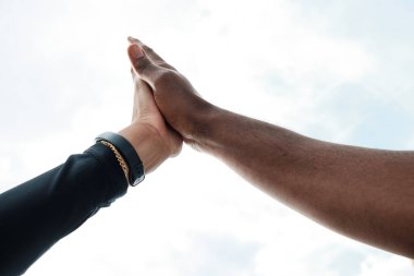 Bir kadınla bir erkek arasında çak bir beşlik. Yüzleri görünmüyor. Arkadaşlık kavramı.