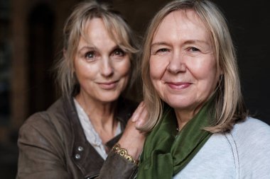 Portrait of two mature friends women looking at camera. One of them is out of focus.