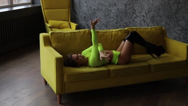 Elastyczna kobieta taniec pasek plastikowy na kanapie — Wideo stockowe