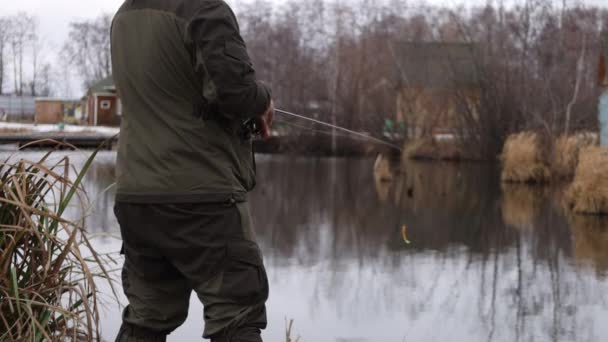 Onherkenbare man aan het vissen in het meer bij dageraad — Stockvideo