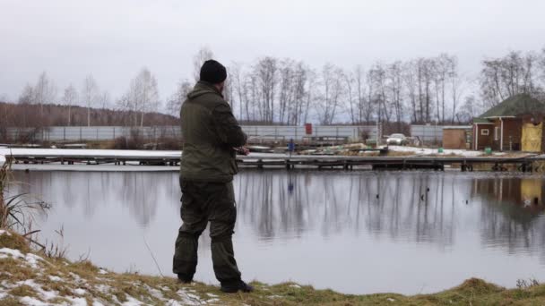 Hombre irreconocible pescando en el lago al amanecer — Vídeo de stock