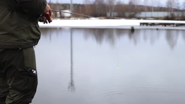 Неузнаваемый человек рыбачит в озере на рассвете — стоковое видео