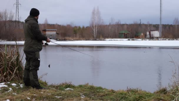 Homem irreconhecível pesca no lago ao amanhecer — Vídeo de Stock