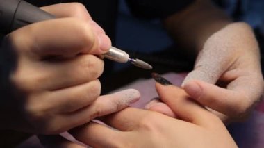 Bayan müşteriye manikür yapan isimsiz bir güzellik uzmanı.