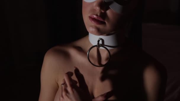 Женщина в маске касается груди — стоковое видео