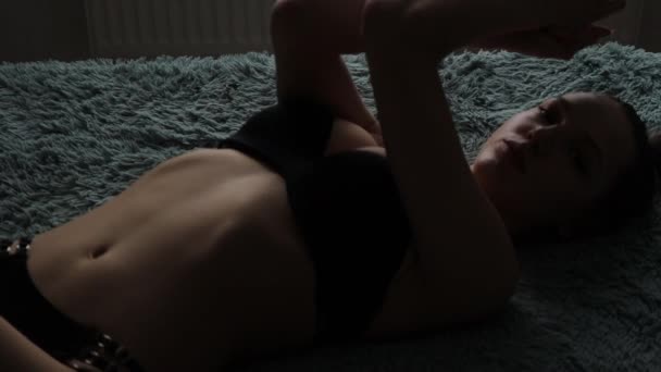 Sensuele vrouw in ondergoed liggend op ruitjes en armen omhoog — Stockvideo