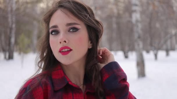 Jeune femme aux cheveux ondulés debout et au visage touchant dans la forêt d'hiver — Video