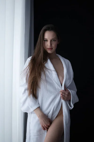 裸胸性感女性站在房间窗户边看着相机的低角度侧视图 — 图库照片