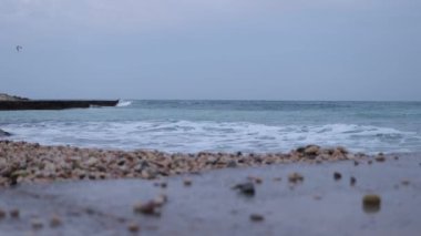 Wet stony coast washed by rippling sea