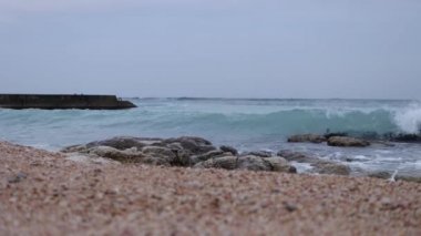 Wet stony coast washed by rippling sea