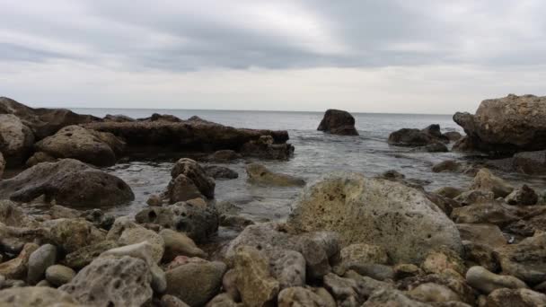 Costa pedregosa húmeda bañada por el mar ondulado — Vídeo de stock