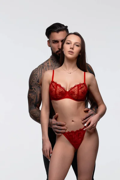 Magabiztos Tetovált Szakállas Férfi Áll Csábító Női Partner Visel Piros — Stock Fotó